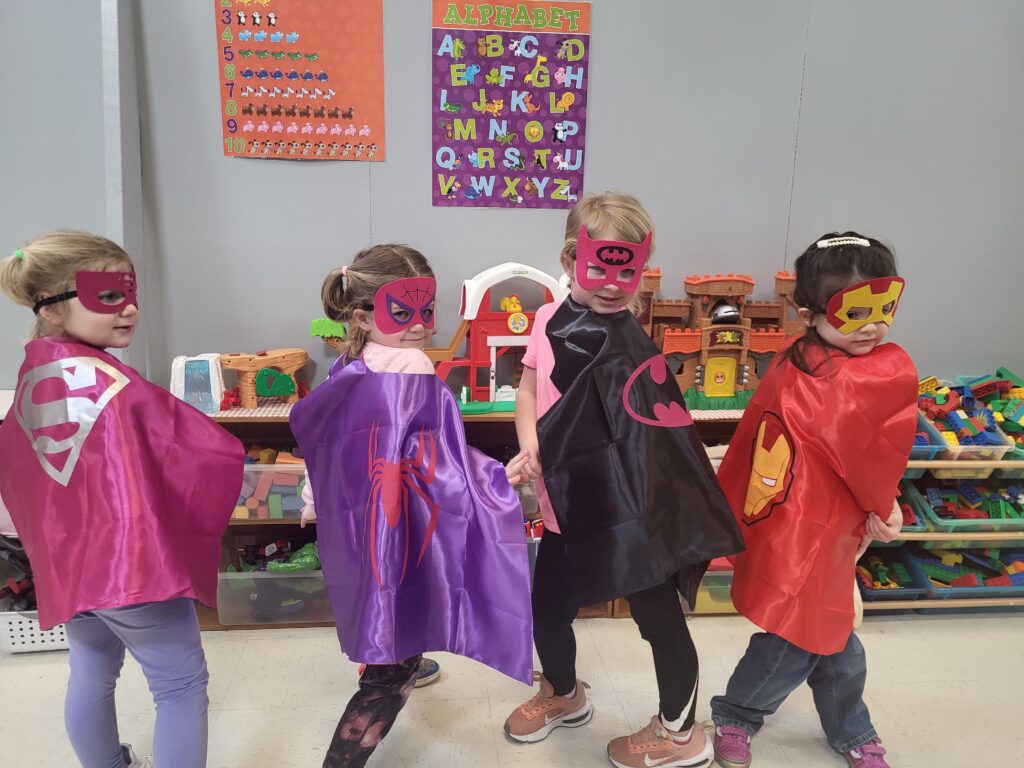 Picture of Kids Club students in superhero costumes.