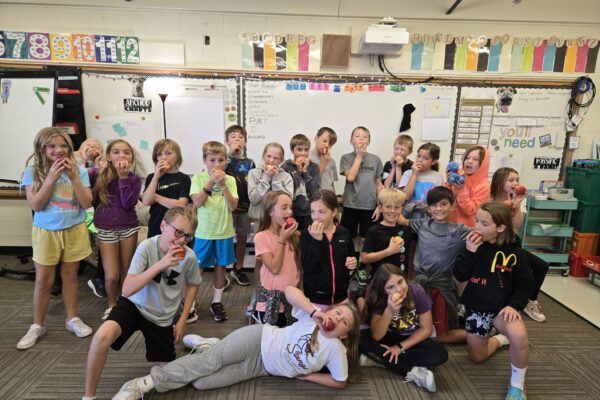 All students taking a bite of their apple.